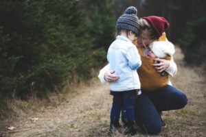 A mother shows good parenting skills as she kneels to talk to her child.