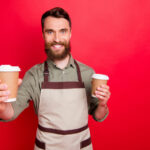 portrait of man offering latte to friend