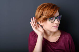 Woman cupping hand to hear what is being said