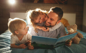 Father reading story to children before going to bed