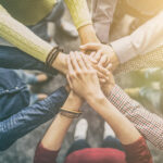 people putting their hands together in a show of unity