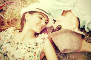 young couple lying head to head in park