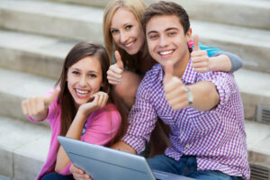 Friends with laptop showing thumbs up